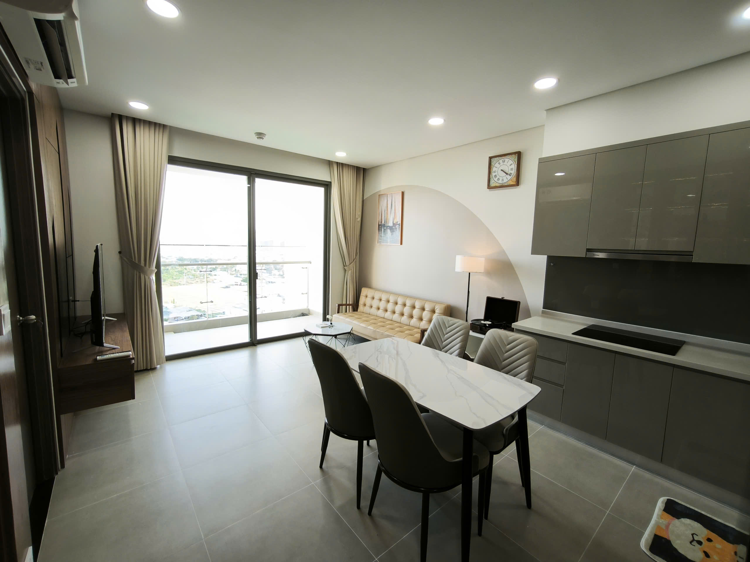 Phòng khách và bếp căn hộ River Panorama với bàn ăn và sofa