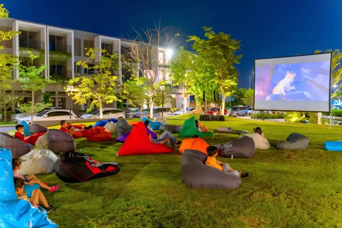 Cư dân xem phim ngoài trời trên thảm cỏ, yếu tố cộng đồng khi so sánh The Gió Riverside và The Standard