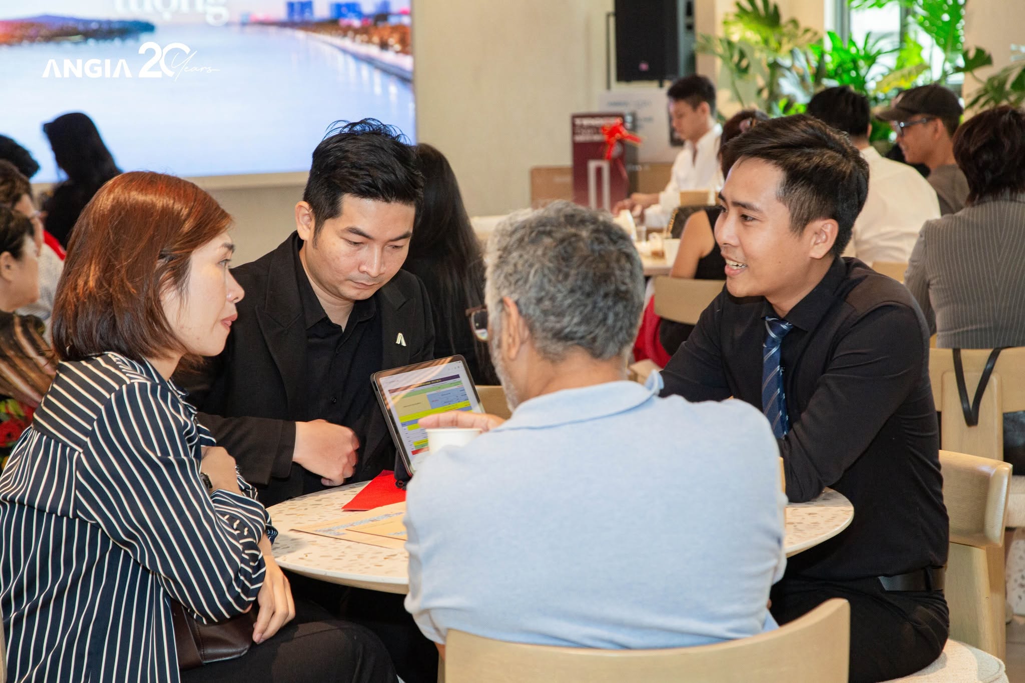 Chuyên viên An Gia tư vấn hồ sơ và bảng giá cho khách hàng tại sự kiện của công ty